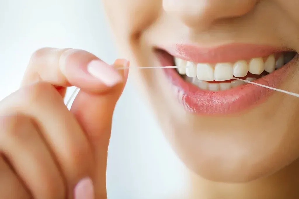 Dental Care. Woman With Beautiful Smile Using Floss For Teeth. High Resolution Image